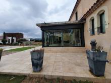 Installation d'une belle véranda en aluminium de la marque Technal de couleur noire près de Mimet