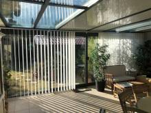 Installation de stores à bandes verticales sur la façade d'une véranda en aluminium TECHNAL à Puyricard